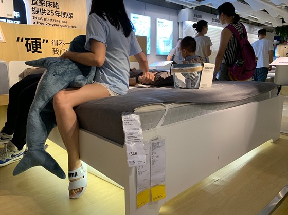 Zákazníci odpoívají na matraci v nabídce obchodního domu. (23. ervna 2019)