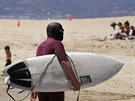 Surfa v ochranné kukle na losangelské Venice Beach (14. kvtna 2020)