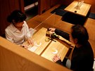 Zákazníci japonské restaurace se vzájemn chrání plexisklovými zábranami. (19....