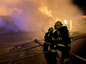 Hasiči zasahují u požáru v areálu Kovošrotu v Dolních Měcholupech.