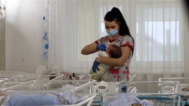 Pečovatelky se na klinice Biotexcom v Kyjevě starají o děti, jejichž biologičtí rodiče si pro ně nemohou kvůli koronaviru přijet. (14. května 2020)