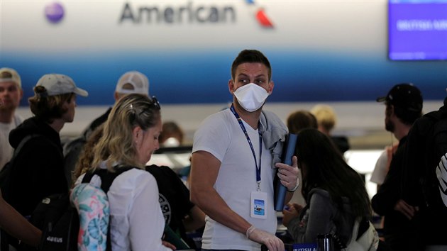 Pasažér s ochrannou rouškou při odbavení na mezinárodním letišti v Miami (21. března 2020)