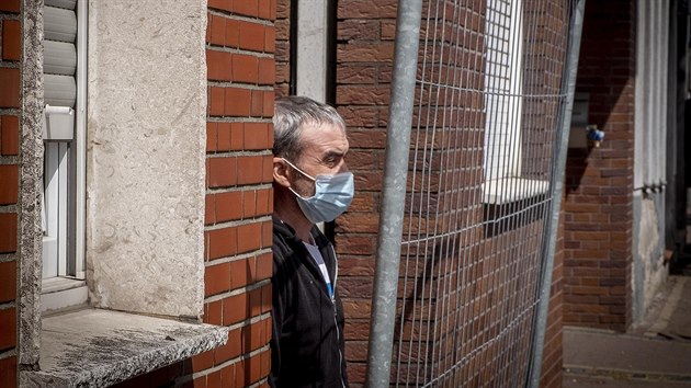 Pracovnk z Rumunska stoj za plotem na ubytovn, kter byla dna do karantny kvli koronavirus. Migranti z vchodn Evropy pracuj na jatkch na jatkch v nmeckm mst Coesfeld, kde vce jak 200 lid mlo pozitivn testy na koronavirus. (12. kvtna 2020)