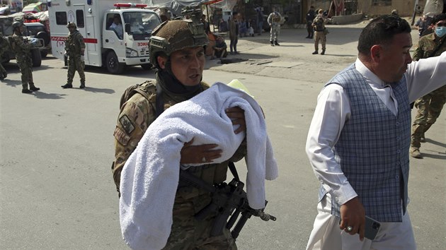 Příslušník afghánských bezpečnostních sil odnáší dítě z porodnice v Kábulu, kterou napadli tři neznámí útočníci. Masakr nepřežilo 24 lidí, mezi mrtvými jsou i dva novorozenci. (12. března 2020)