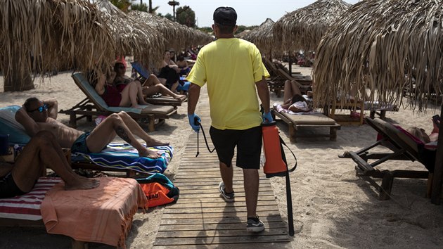 Zaměstnanec řecké pláže dezinfikuje lůžka. Vláda otevřela pláže, Řekové ale musí dodržovat hygienická pravidla a udržovat sociální vzdálenost. (16. května 2020)