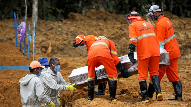 Zaměstnanci pohřební služby pohřbívají Brazilce, kteří zemřeli na koronavirus. (13. května 2020)