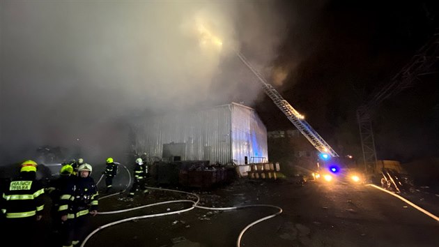 Hasiči v Praze 15 v noci likvidovali požár odpadu v kovošrotu v ulici Ke Kablu. Plameny ohrožovaly i přilehlou halu a cisternu s naftou, kterou se hasičům podařilo ochladit a uchránit. (10. května 2020).