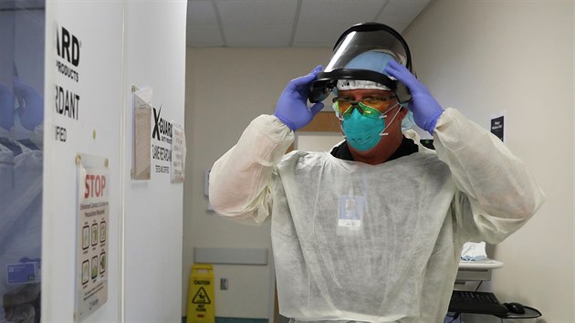 Respirační terapeut Casey White se připravuje na návštěvu pacientů s onemocněním covid-19 na jednotce intenzivní péče nemocnice Scripps Mercy v Kalifornii. (13. května 2020)