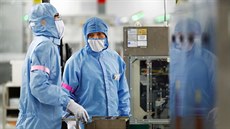 Zamstnanci pekingské továrny Renesas Semiconductor Co. v ochranných oblecích...