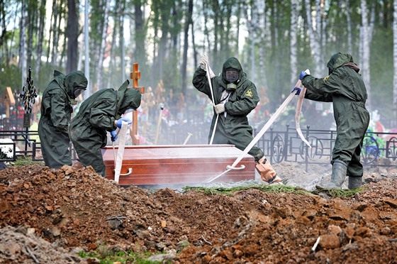 Pracovníci hbitova na okraji Moskvy bhem pohbu jedné z obtí koronaviru (15....