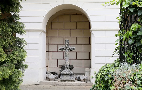 Pískovcový kříž s přírodními motivy stál původně nedaleko košťanského zámečku.