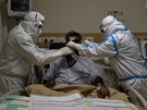 Lékaský tým v ochranných oblecích peuje o pacienta s onemocnním covid-19 v...