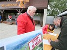 Lidé podepisují v areálu SK Baník Modlany petici proti výstavb hal za vesnicí...