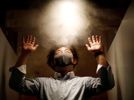 Mu v oblaku dezinfekce pi vstupu do japonsk restaurace (21. kvtna 2020)