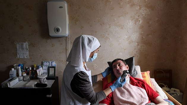 Zdravotn sestra se star o mue v peovatelskm dom v Moskv. (16. kvtna 2020)