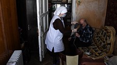 Zdravotní sestra pečuje o seniora u něj doma v Moskvě. (25. května 2020)