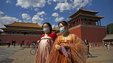 eny v tradiních atech procházejí v centru Pekingu. (27. kvtna 2020)