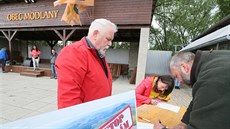 Lidé podepisují v areálu SK Baník Modlany petici proti výstavbě hal za vesnicí...
