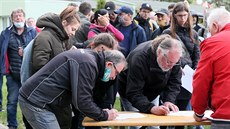 Lidé podepisují v areálu SK Baník Modlany petici proti výstavb hal za vesnicí...