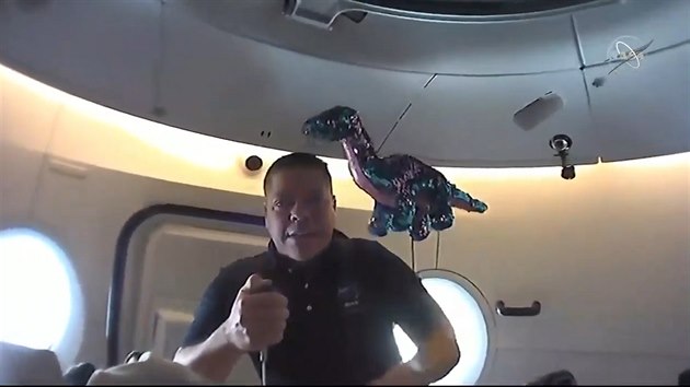 Astronaut Robert Behnken na lodi Crew Dragon demonstruje beztížný stav..