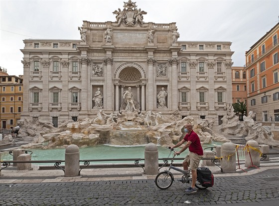 Cyklista s rouškou před Fontánou di Trevi. (9. května 2020)