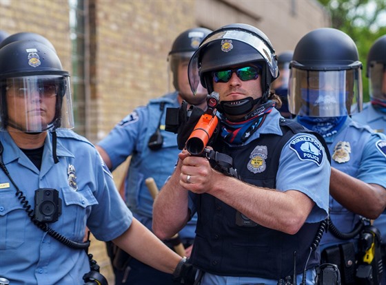Ozbrojený policista míí do davu protestujících v Minneapolisu. (27. kvtna...