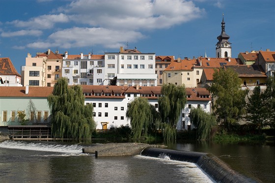 Pohled na siluetu msta, kterým protéká pvabná eka Otava.