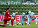 Fotbalisté Wolfsburgu (vlevo) i Brém ped ligovým zápasem poklekli, aby ukázali...