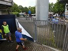 Pracovníci olomouckého klubu odstraují ped zápasem z plotu plachtu, aby...