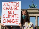Zmna systému, ne klimatu, hlásá transparent mladé demonstrantky v Berlín....