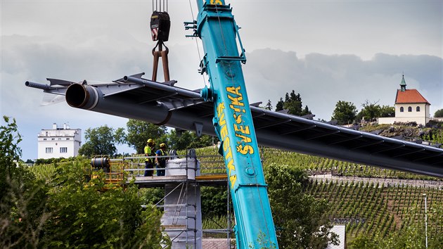 Dělníci v úterý usadili mezi pražskou Trojou a Císařským ostrovem hlavní část nové lávky přes Vltavu. 75 metrů dlouhé a 90 tun vážící prostřední pole mostu pomáhaly přesunout dva jeřáby. (9. června 2020)