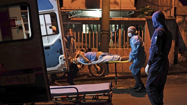 Mui v ochrannch oblecch pevej pacienta s pznaky covid-19 do nemocnice v Manacapuru. (4. ervna 2020)