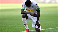Fotbalista Mönchengladbachu Marcus Thuram po vst�eleném gólu poklekl, aby...