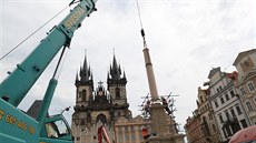 Socha�i pomocí je�ábu umístili na podstavec �ást sloupu, které se �íká d�ík....