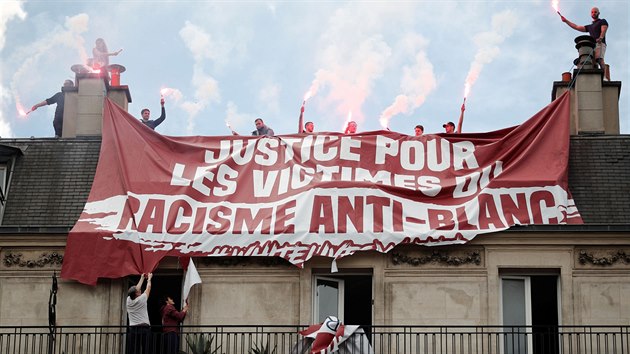 Opoziční demonstranti na jednu z budov na pařížském náměstí Republiky vyvěsili transparent s nápisem “Spravedlnost pro oběti protibílého terorismu”. (13. června 2020)