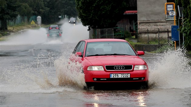 Auta přejíždějí zatopenou silnici u Životic u Nového Jičína. (19.6.2020)