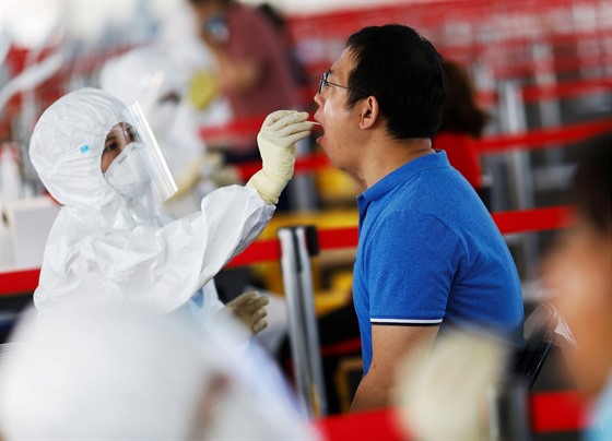 Muž v ochranném obleku odebírá vzorek pro testování. Pekingské úřady se obávají...