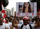 Demonstrant drí transparent s fotkou Khalify a nápisem "Ona si zaslouí více...