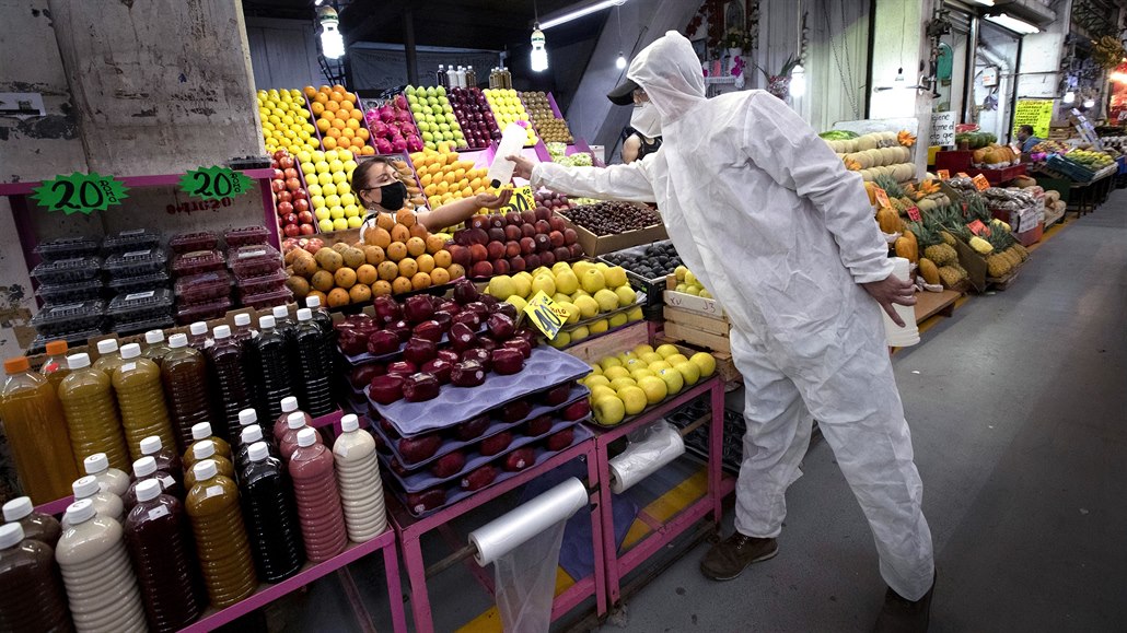 Zdravotník v ochranném obleku rozdává na trhu Central de Abasto v Mexico City...