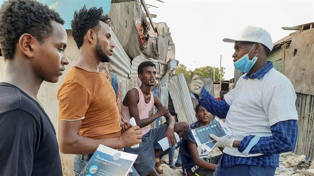 Spolupracovník Mezinárodní organizace pro migraci (IOM) předává etiopským migrantům informace o koronaviru. Někteří migranti na somálské hranici nemají o existenci viru vůbec ponětí. (20. května 2020)