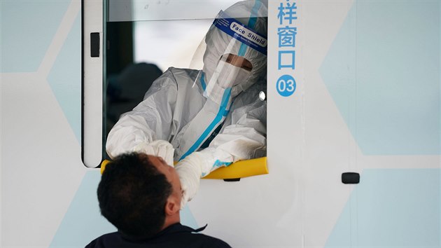 Mu v ochrannm obleku odebr vzorek pro testovn. V Pekingu se plonm testovnm sna zabrnit dalmu en koronaviru. (28. ervna 2020)