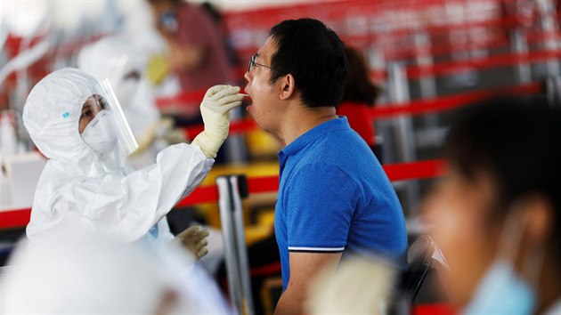 Mu v ochrannm obleku odebr vzorek pro testovn. Pekingsk ady se obvaj druh vlny pandemie. (24. ervna 2020)
