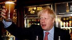 Britský premiér Boris Johnson drží sklenici piva v londýnské hospodě...