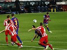 Barcelonský Lionel Messi nakopává mí do pokutového území Atlética Madrid.