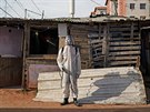 Pracovník v ochranném obleku dezinfikuje prostory v chudinské oblasti v Rio de...
