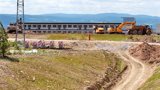 Nedaleko napojení Podkrušnohorské výsypky už také stojí zázemí stavby testovacího centra BMW. (30. června 2020)