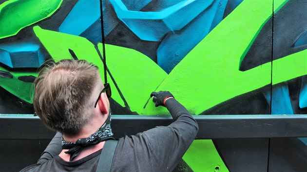 Karlovarský streetartový umělec Real143 při malbě graffiti na stěny u ramp do podchodů z Varšavské ulice.