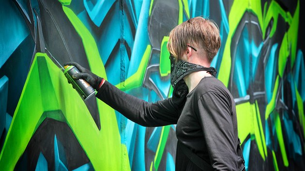 Karlovarský streetartový umělec Real143 při malbě graffiti na stěny u ramp do podchodů z Varšavské ulice.