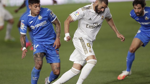 Karim Benzema (uprosted) z Realu Madrid sthan  Mathiasem Oliverou (vlevo) z Getafe.