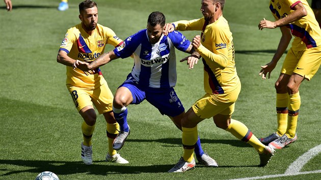 Edgar Mendez (uprosted) z Alaves se sna probt mezi barcelonskmi Jordim Albou (vlevo) a Clementem Lengletem.